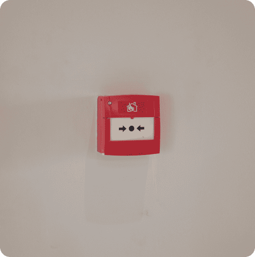 Boîtier de déclencheur manuel d'alarme incendie rouge installé sur un mur gris