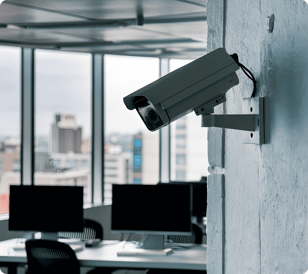 Caméra de sécurité intérieure noire fixée au mur d'un bureau professionnel moderne