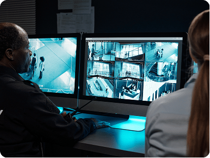 Opérateurs de sécurité surveillant des locaux de nuit sur des écrans de contrôle de télésurveillance
