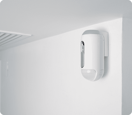 Détecteur de mouvement infrarouge intérieur blanc installé dans l'angle d'une pièce